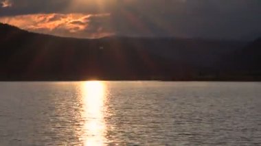 Gün batımını dağlarda gölün üzerinde
