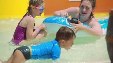 Şilte üzerinde yüzen çocuklar ile anne