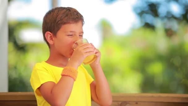 Chico está bebiendo jugo de naranja — Vídeos de Stock