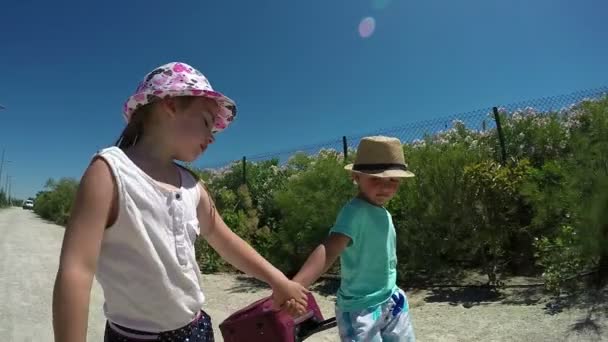 Chica y niño tomados de la mano — Vídeo de stock