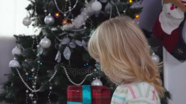 Küçük kız Noel ağacının yanında gülüyor