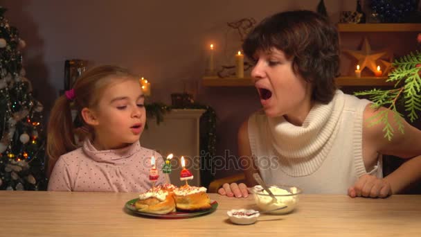 Moeder en dochter het afblazen van de Kerst kaarsen — Stockvideo