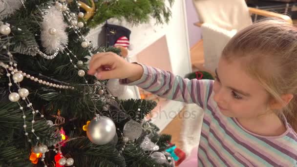 Little girl decorates a Christmas tree — Stock Video