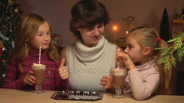 As meninas bebem chocolate quente através de uma palha — Vídeo de Stock