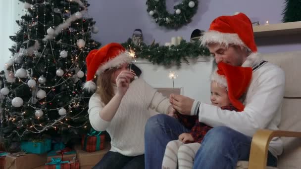 Familia joven alrededor del árbol de Navidad — Vídeos de Stock