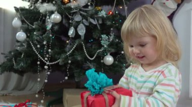 Küçük bir kız bir Hediyelik Noel ağacı yakınındaki seçer