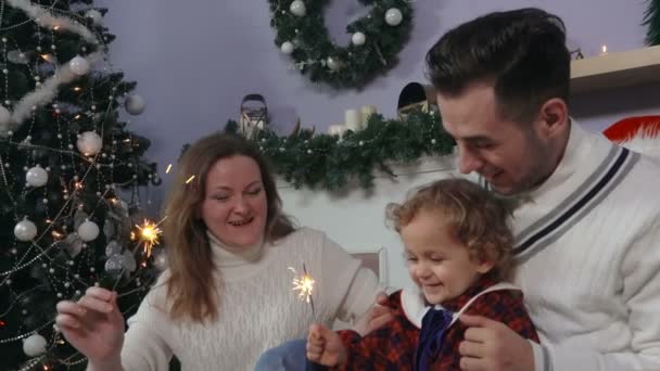 Familia joven alrededor del árbol de Navidad — Vídeos de Stock