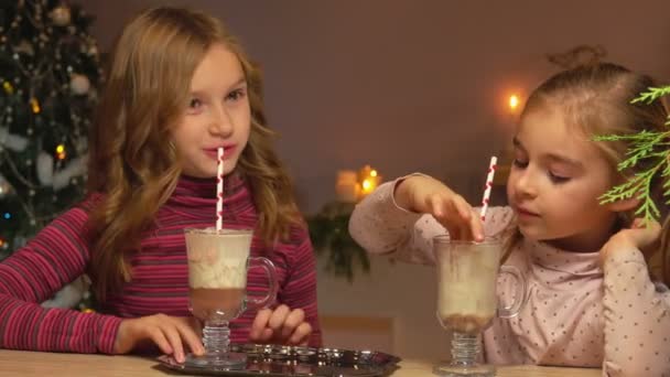 As meninas bebem chocolate quente através de uma palha — Vídeo de Stock