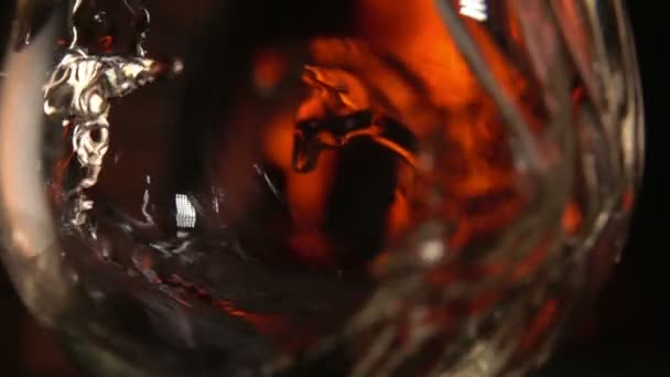 Close-up Champagne wordt gegoten in een glas op een achtergrond van brand — Stockvideo