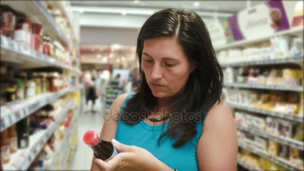 Mujer elige la salsa en el supermercado — Vídeos de Stock