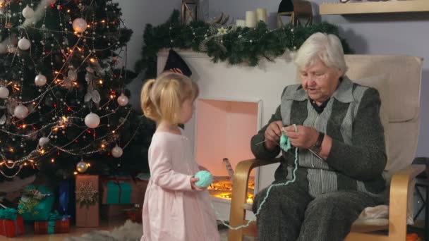 Grootmoeder breit een sok zittend in een stoel — Stockvideo