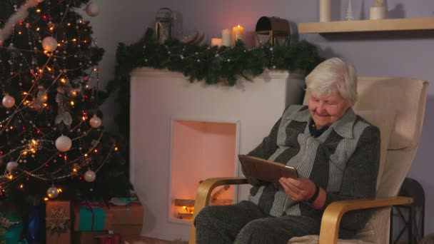 Пожилая женщина читает послание на скрижали — стоковое видео