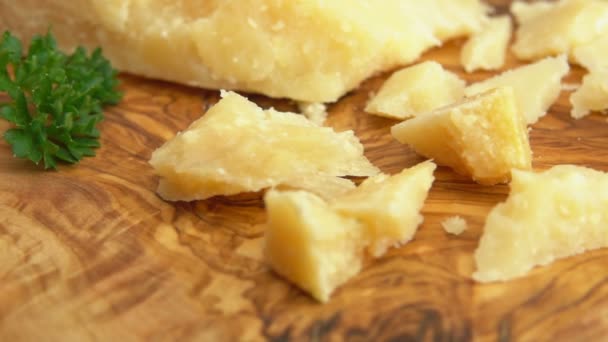 Вилка берет кусок сыра Пармезан из деревянной доски — стоковое видео