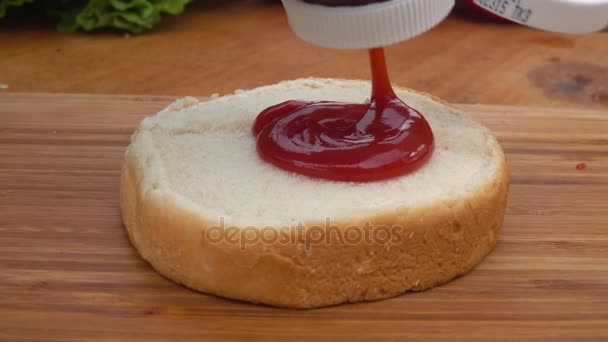 Ketchup squeeze on toast bun — Stock Video