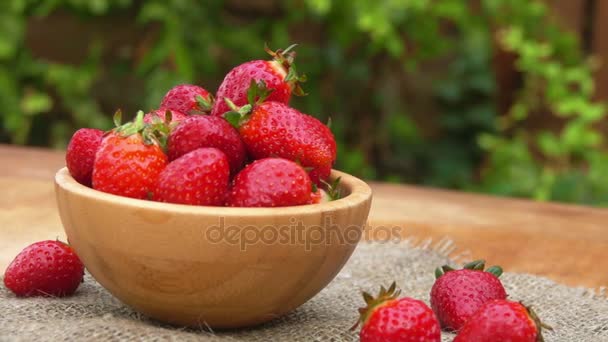 Hand neemt een aardbei uit een kom — Stockvideo