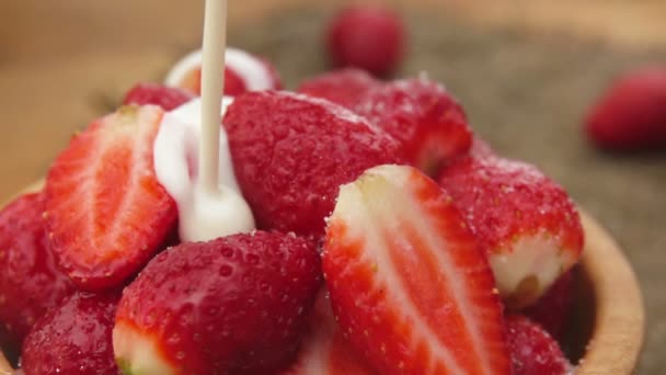 Strawberries in the bowl poured with cream — Stock Video