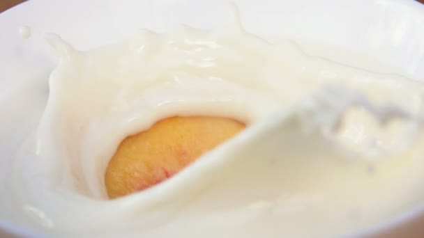 Rodaja de melocotón flotando en crema — Vídeo de stock