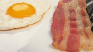 Yumurtalı beyaz tabakta pastırma koyar