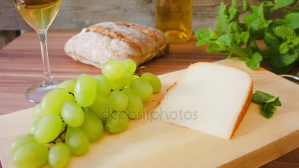 Kemény sajt fehér borral. szőlő és kenyér — Stock videók