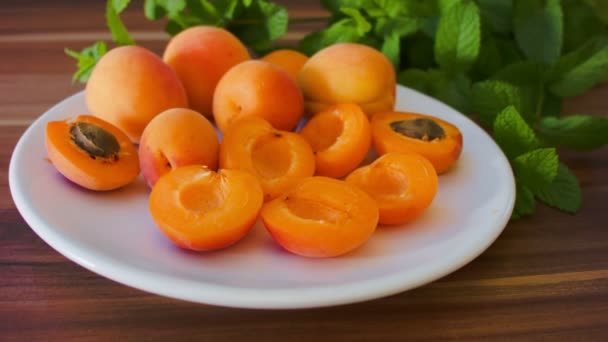 Ripe tasty apricot on a white plate — Stock Video