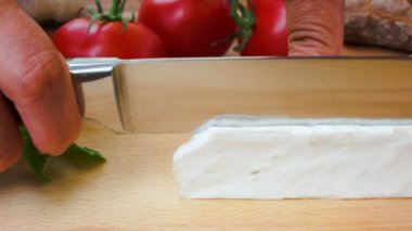 Brie peyniri bir ahşap tahta üzerinde kesmek