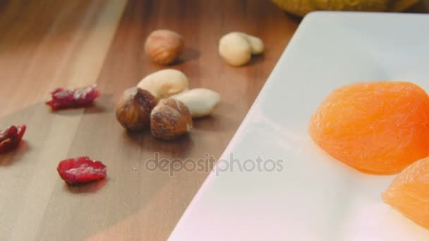 Primer plano de frutos secos y frutos secos acostados en el plato — Vídeos de Stock