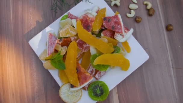 Childrens hand take candied fruits from the plate — Stock Video