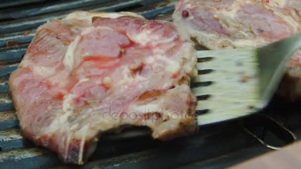 Špachtlí převrátí pečený steak na grilu — Stock video