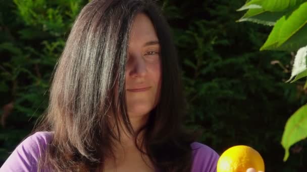 Женщина держит апельсин — стоковое видео