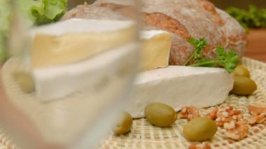 Beyaz şarap cam ve brie peyniri dökülür