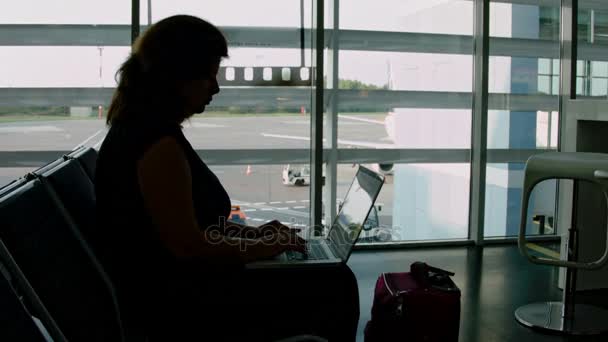 Γυναίκα που εργάζεται σε ένα φορητό υπολογιστή στο αεροδρόμιο — Αρχείο Βίντεο