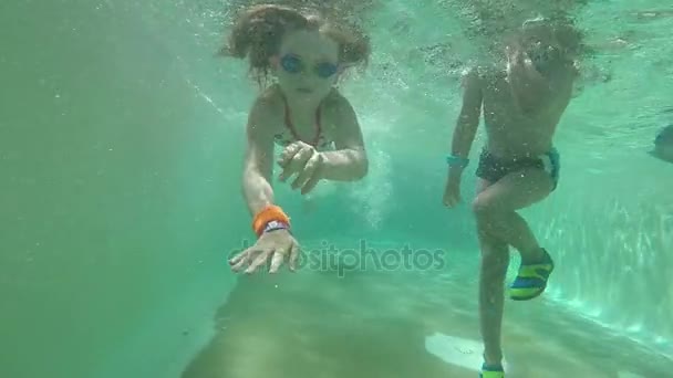 Girl and boy swimming under water — Stock Video