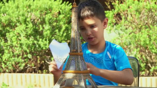 Niño jugando con un avión de papel — Vídeo de stock