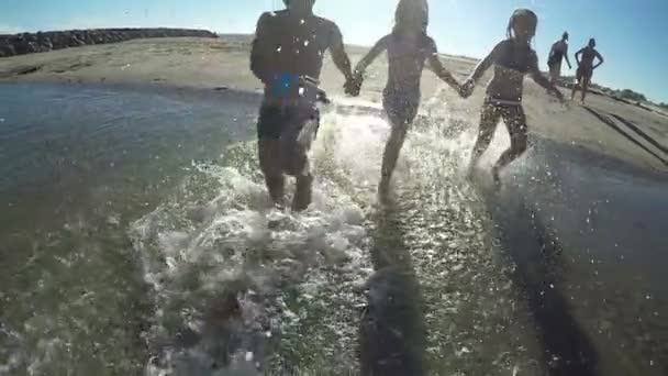 Crianças de mãos dadas correndo na água — Vídeo de Stock