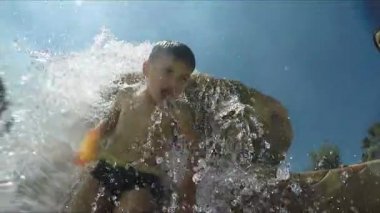 Küçük güzel çocuk su jetleri altında duruyor