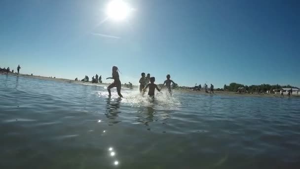 Niños jugando con pistola de agua de playa — Vídeos de Stock