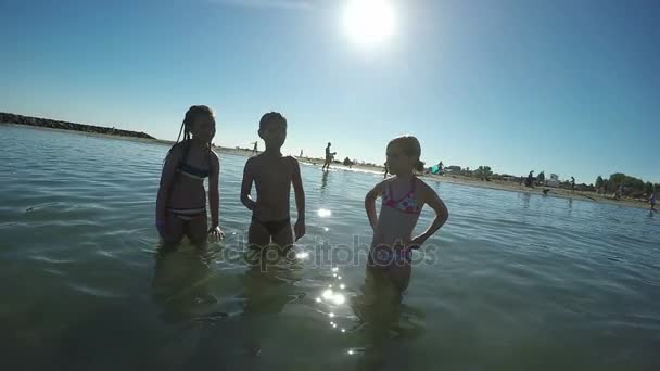 Twee meisjes en een jongen die permanent in het water — Stockvideo