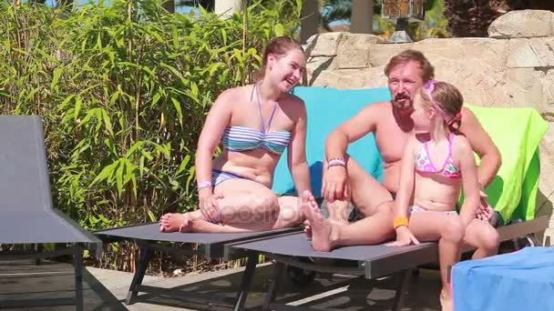 Family resting on the sun loungers — Stock Video