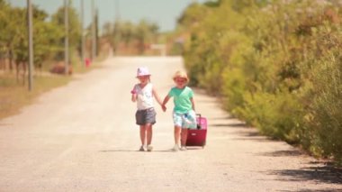 Mutlu küçük kız ve erkek elele, yolda gitmek