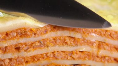 İtalyan lazanya parçası bıçak kesiyor