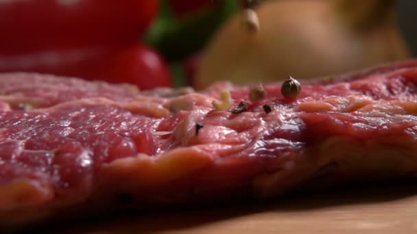 Mixture of peppers falling on a beef steak — Stock Video