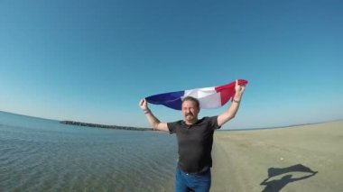 Fransa bayrağı tutan bir adam çalışır