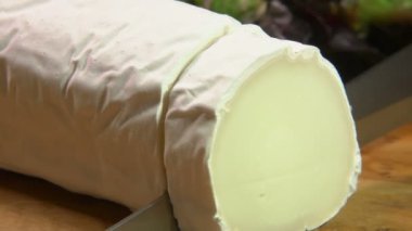 Keçi peyniri ile gri küf parçasını bir bıçak ile kesmek