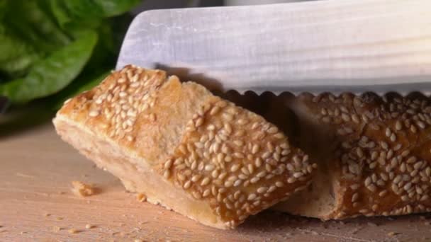 Cut piece of baguette with sesame seeds falls — Stock Video