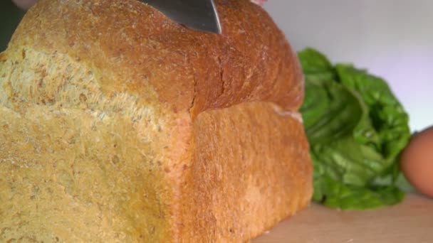 Kruimels vliegen van het mes snijden graan brood — Stockvideo