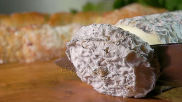 Corteza apetitosa cortada con un cuchillo de queso de cabra — Vídeo de stock