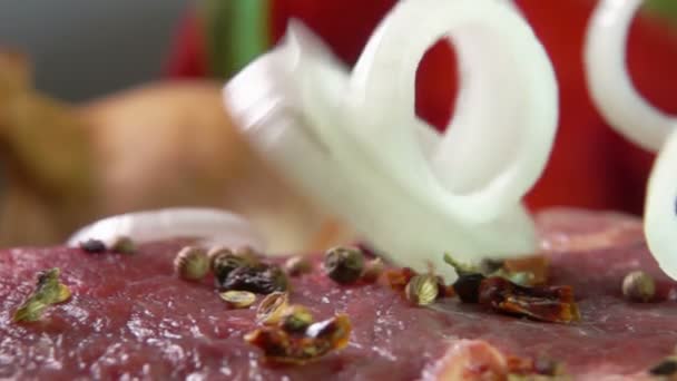 Луковые кольца падают на мясной бифштекс — стоковое видео
