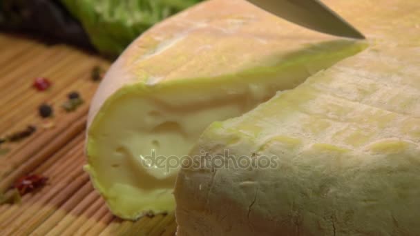 Il coltello taglia un pezzo di una testa rotonda di formaggio di pecora morbido — Video Stock