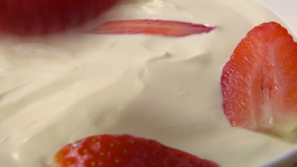 Piece of strawberries falling into the jar with whipped cream — Stock Video