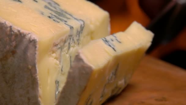 Повільний рух блакитного сиру, що падає на дерев'яну дошку — стокове відео
